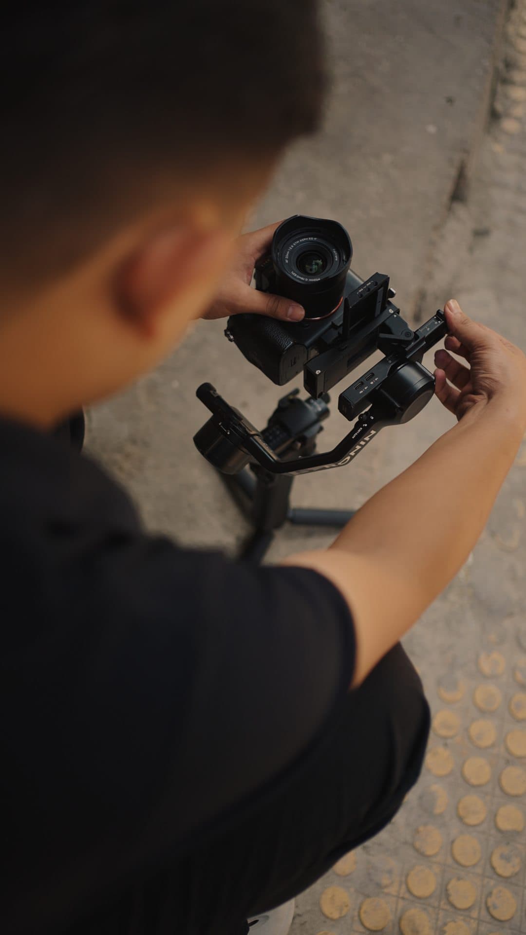 Over-the-shoulder view of a crew member framing a shot on a gimbal
